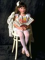 Free Stock Photo: A cute young girl posing in a chair with a fan