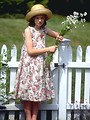 Free Stock Photo: A young girl standing by a wooden fence with flowers
