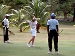 Free Stock Photo: A woman swinging a golf club on tropical course
