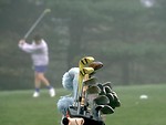 Free Stock Photo: A set of golf clubs and a manabout to swing