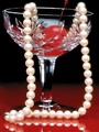 Free Stock Photo: A glass with a cherry and string of pearls in it