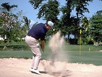 Free Stock Photo: A golfer hitting a golf ball out of a sand trap