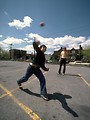 Free Stock Photo: A young boy playing with a ball in a parking lot