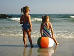 Free Stock Photo: Two young girls watching the sun on the beach