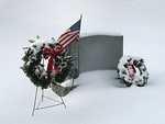 Free Stock Photo: A blank snow covered tombstone with a US flag and wreaths