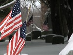 Free Stock Photo: Closeup of US flags and tombstones in a snow covered graveyard
