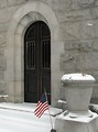 Free Stock Photo: Entrance door of a small stone mausoleum with a US flag
