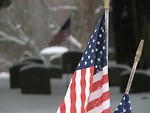 Free Stock Photo: Closeup of US flags and tombstones in a snow covered graveyard