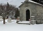 Free Stock Photo: A small mausoleum with US flags in a snow covered graveyard