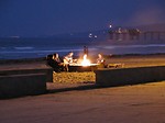 Free Stock Photo: A group sitting around a campfire on a beach at night
