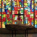 Free Stock Photo: A small cross and a bible in front of a stained glass window
