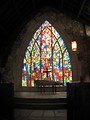 Free Stock Photo: A small cross in front of a stained glass window