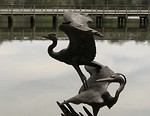 Free Stock Photo: A statue of birds overlooking a bridge over water
