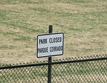 Free Stock Photo: A closed sign in English and Spanish in front of a park