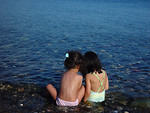 Free Stock Photo: Two young girls sitting on the beach by the water