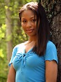 Free Stock Photo: A beautiful African American teen girl posing against a tree in the woods