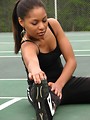 Free Stock Photo: A beautiful African American teen girl stretching on a tennis court