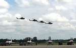 Free Stock Photo: AH-1F Cobra attack helicopters flying over a runway with Thunderbird jets