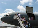 Free Stock Photo: Front view of a military plane on the runway with people on truck mounted passenger stairs