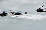Free Stock Photo: AH-1F Cobra attack helicopters flying with smoke trails in the sky