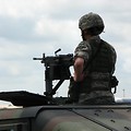 Free Stock Photo: A female soldier on top of a humvee with a gun