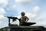 Free Stock Photo: A female soldier on top of a humvee with a gun