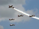 Free Stock Photo: Vintage SNJ-2 WW2 fighter planes flying in formation with smoke trails