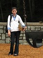 Free Stock Photo: A young schoolgirl carrying books and a bookbag by a playground