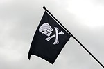 Free Stock Photo: A skull and crossbones pirate flag flying in the sky