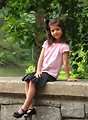 Free Stock Photo: A cute young latina girl posing outdoors on a stone wall