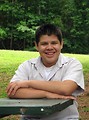 Free Stock Photo: A teen latino boy sitting at a picnic table outdoors
