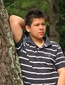 Free Stock Photo: A young latino man posing outdoors by a tree.