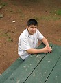 Free Stock Photo: A teen latino boy sitting at a picnic table outdoors