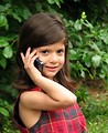 Free Stock Photo: A cute young latina girl posing with a cell phone