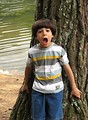 Free Stock Photo: A young latino boy with a surprised expression posing by a lake