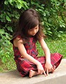 Free Stock Photo: A cute young latina girl sitting on a stone wall