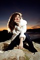 Free Stock Photo: A beautiful woman in a jacket posing in front of a sunset