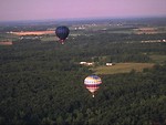 Free Stock Photo: Hot air balloons flying over a field and trees