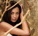 Free Stock Photo: A beautiful brunette in a bikini posing against a rock.
