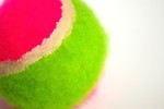 Free Stock Photo: A pink and green tennis ball isolated on a white background.