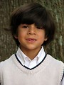 Free Stock Photo: A young latino boy posing by a tree