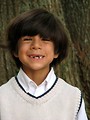 Free Stock Photo: A young latino boy posing by a tree