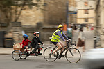 Free Stock Photo: A woman riding a bike with kids in a trailer
