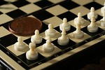 Free Stock Photo: Close-up of a miniature chess set with a coin