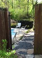 Free Stock Photo: A pool and chairs in a backyard behind a fence