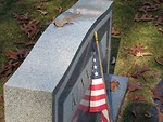 Free Stock Photo: US flag leaning against a tombstone