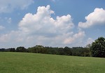 Free Stock Photo: A large grass field with a blue cloudy sky