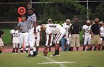 Free Stock Photo: A high school football player setting a ball up for a kick
