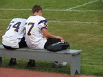 Free Stock Photo: High school football players sitting on a bench by a field