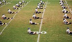 Free Stock Photo: High school football players doin warm up exercises on a field